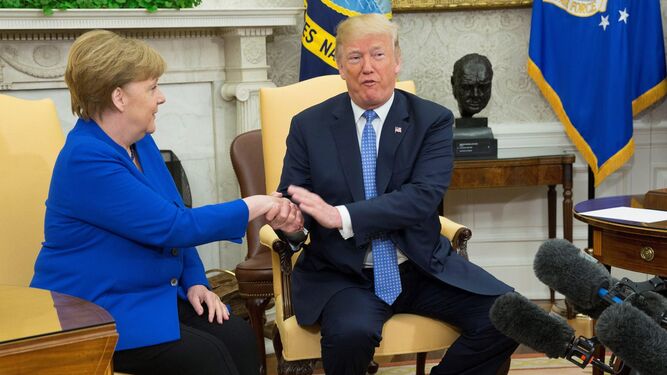 Donald Trump estrecha la mano a Angela Merkel durante su encuentro ayer en la Casa Blanca.