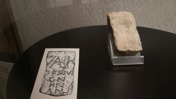 Una imagen del fragmento de calendario romano expuesto en el Museo de Cádiz, junto con una lámina que clarifica su inscripción.
