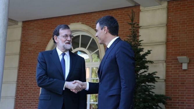 Mariano Rajoy saluda a Pedro Sánchez en la puerta del Palacio de l aMoncloa.