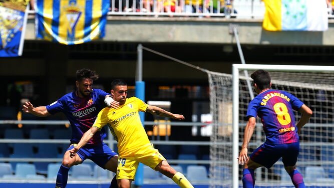 Dani Romera sufre el estrecho marcaje de David Costas delante de Sarsanedas durante el partido del Cádiz contra el Barcelona B.