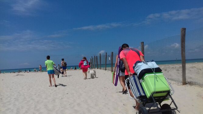 Varias familias, ayer, al acceder a la playa de Camposoto para pasar el día.