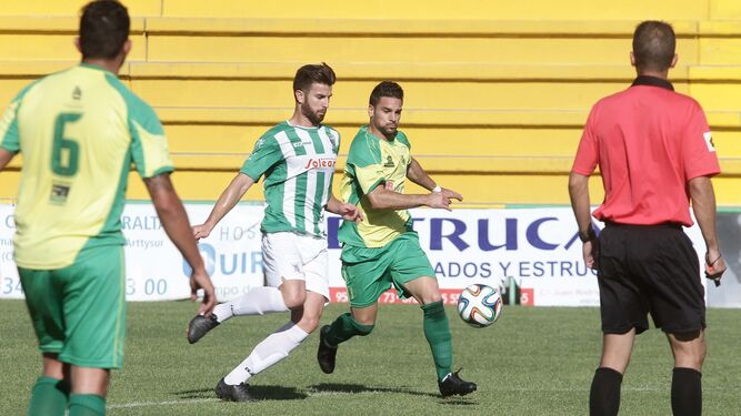 Oca se lleva un balón ante un jugador de Los Barrios cuando militaba en el Atlético Sanluqueño.
