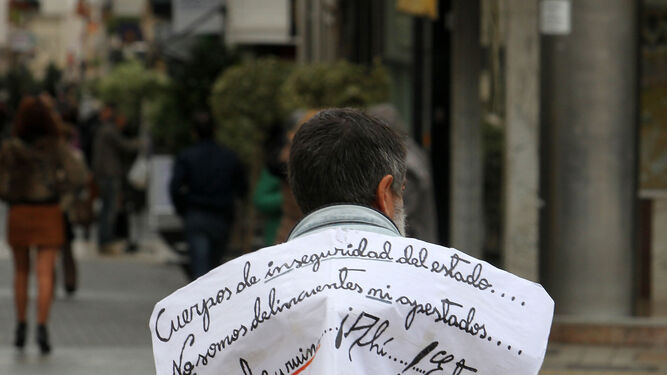 Un hombre pide ayuda en una calle de Huelva.
