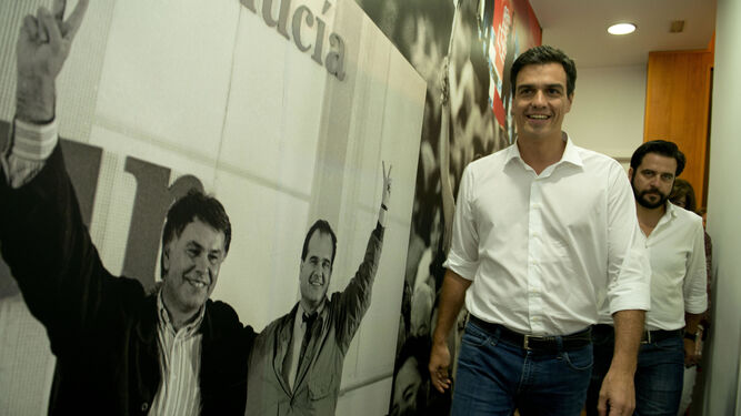 Pedro Sánchez pasa junto a una gigantesca fotografía de Felipe González y de Manuel Chaves en la sede local del PSOE de Cádiz, en una imagen de archivo.