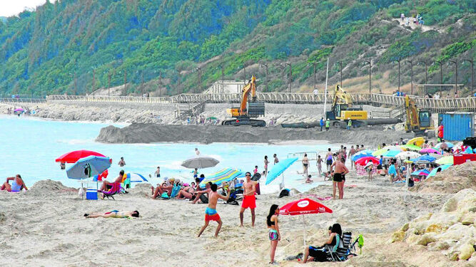 Una imagen de la playa de Las Redes, donde ayer coincidieron los bañistas y las máquinas trabajando en las obras de regeneración de la arena.
