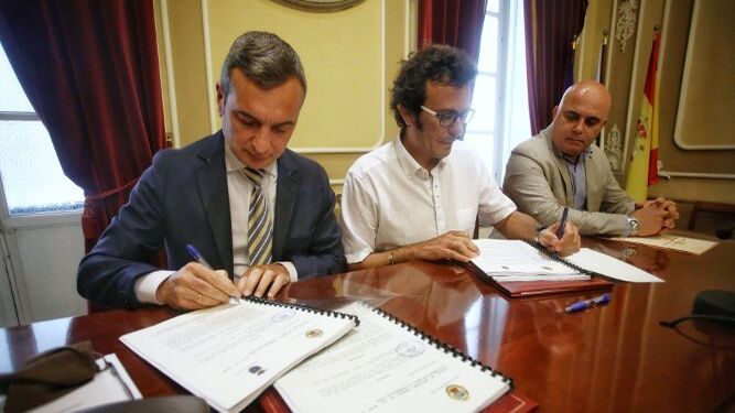 El rector, Eduardo González Mazo, y el alcalde, José María González, firman el convenio en presencia del teniente de alcalde David Navarro.