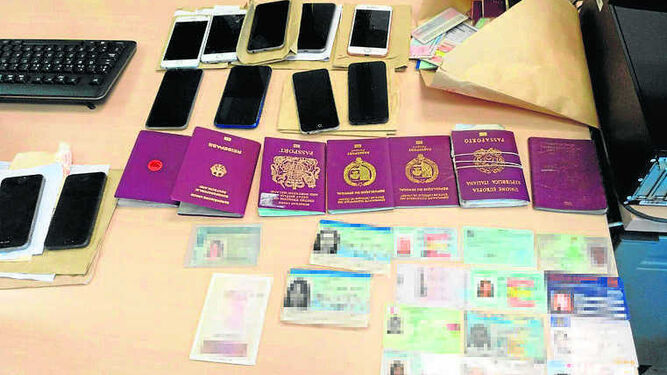 Móviles, pasaportes y carnés falsos requisados a la banda de estafadores.