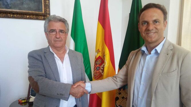 El empresario Juan Reverte y el alcalde se estrechan la mano tras la firma del contrato.