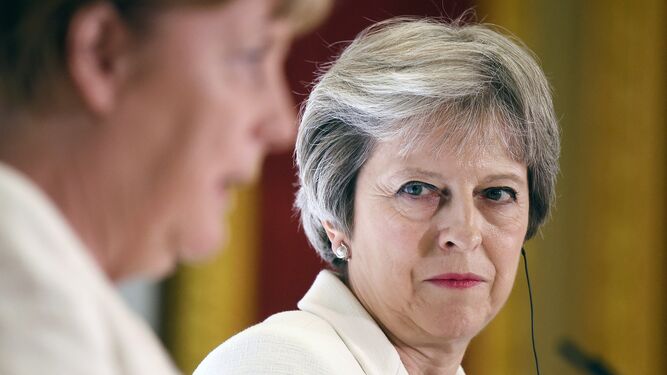 La 'premier' británica, Theresa May, observa ayer la intervención de la canciller alemana, Angela Merkel, en Londres.