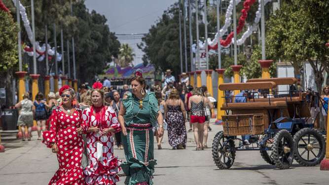Mujeres vestidas con trajes de volantes y lunares caminan por el recinto de La Magdalena.