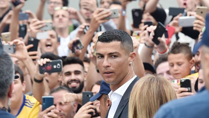 Cristiano Ronaldo, entre una nube de teléfonos móviles mientras es aclamado por la multitud a su llegada a la clínica J Medical, en Turín.