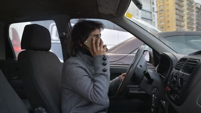 Imagen simulada de una persona usando el móvil al volante.