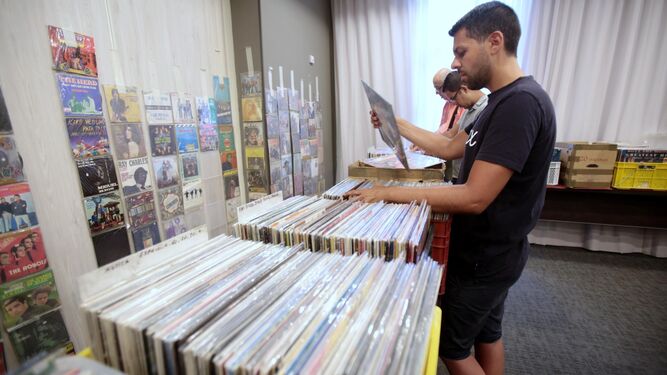 Un hombre revisa la inmensa colección de discos que se exponía en la muestra.