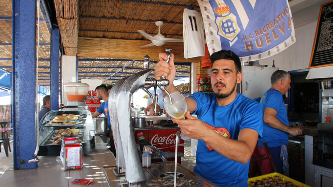 Miguel Ángel, camarero del chiringuito Oliver, sirve una cerveza.