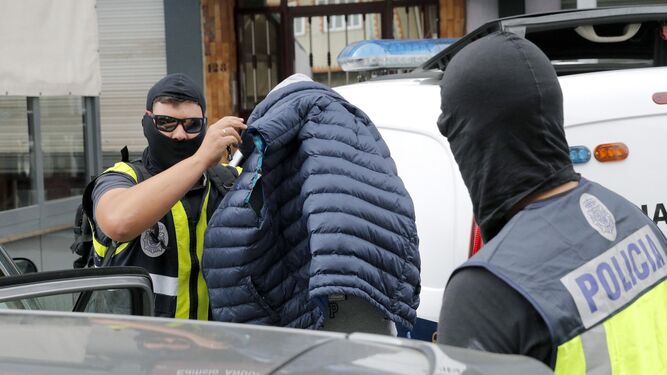 Dos agentes trasladan a un detenido ayer en un local de Boiro (La Coruña).