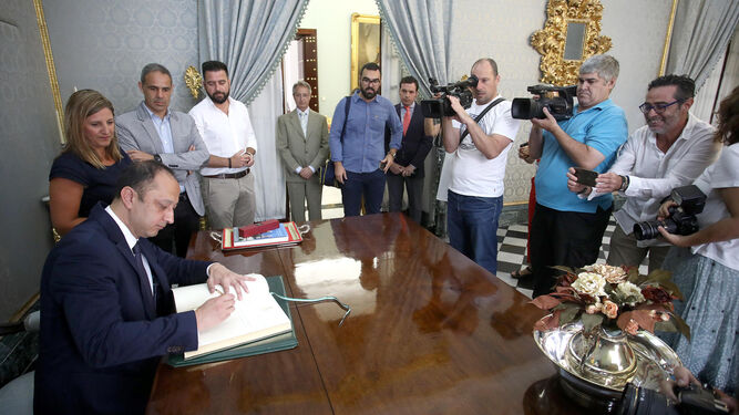 El delegado del Gobierno en Andalucía firma en el libro de honor de la Diputación, junto a Irene García.