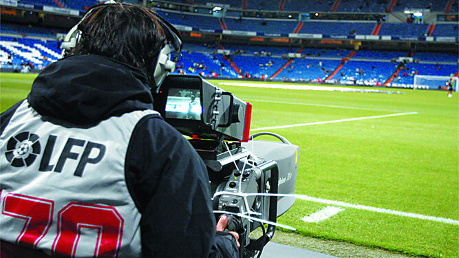 Un cámara en la banda de un campo de fútbol.