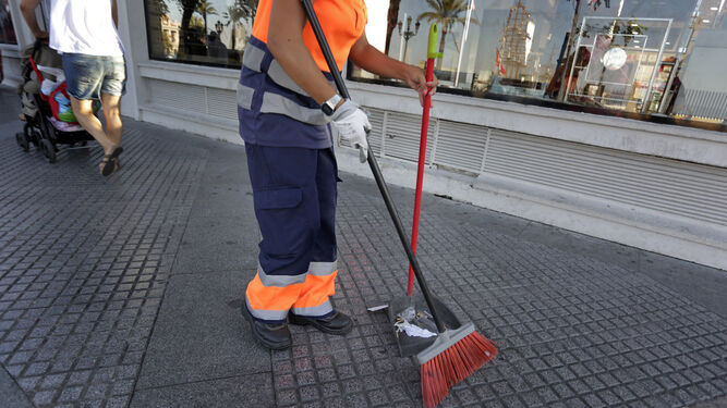 Una empleada del servicio de limpieza realiza su trabajo en una calle de la ciudad.