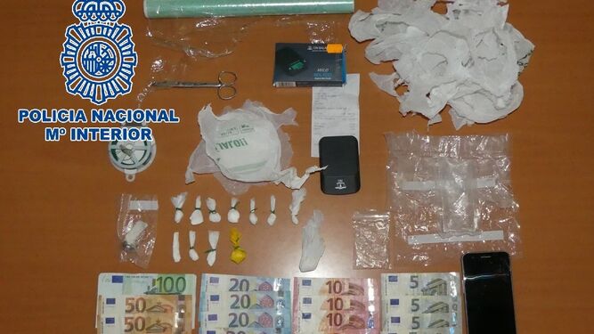 El dinero, la droga y otros objetos incautados al detenido.