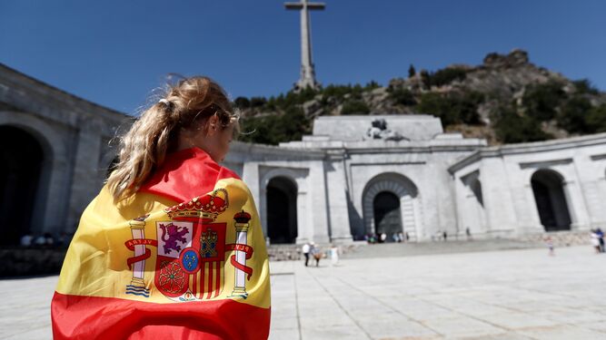 Una joven, envuelta por una bandera en la explanada del Valle de los caídos.