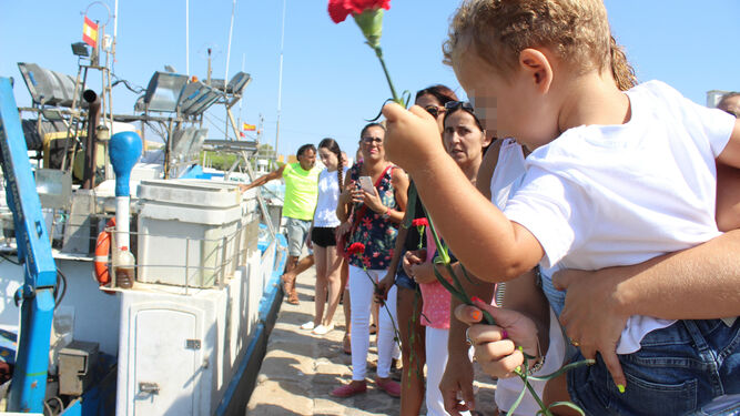 El hijo de un marinero del Pepita Aurora lanzaba un clavel a la mar en 2017.