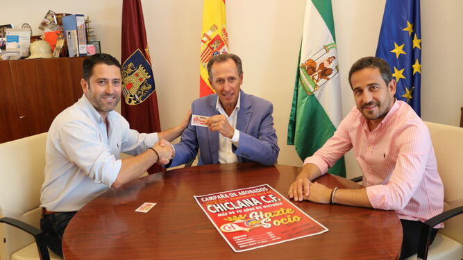 Rojo (i) hace entrega del carnet a Román, en presencia del concejal de deportes.