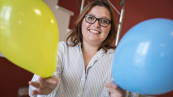 Noelia Áspera Loureiro con un globo verde y otro azul, colores que representan la hipertensión intracraneal idiopática.