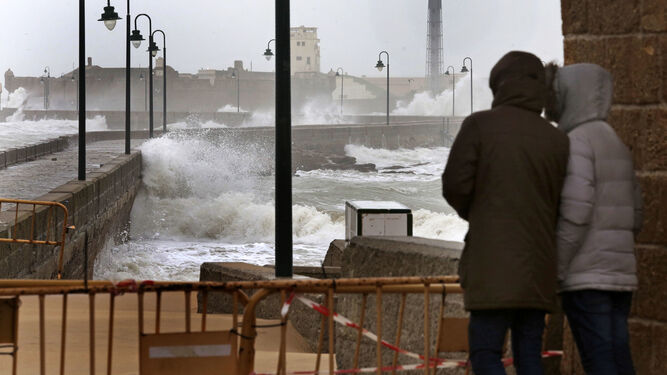 Dos personas observan los efectos del temporal que azotó Cádiz el pasado mes de marzo.