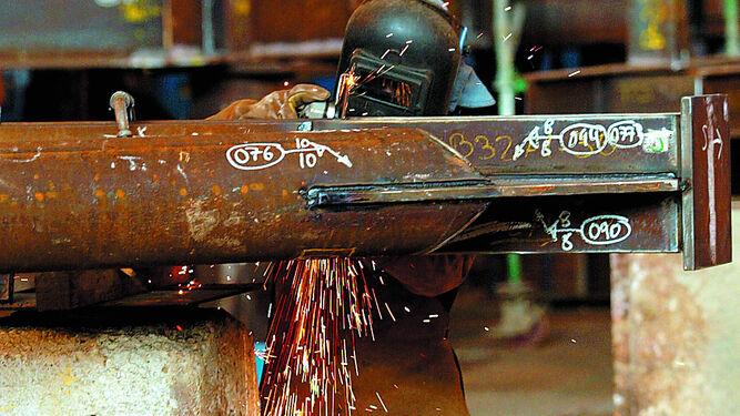 Un soldador realiza su trabajo en una viga de hierro.
