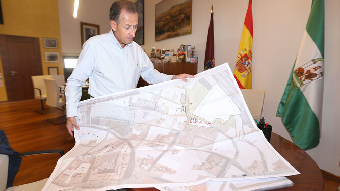 El alcalde, José María Román, muestra uno de los planos que contiene el borrador del proyecto de puesta en valor del yacimiento.