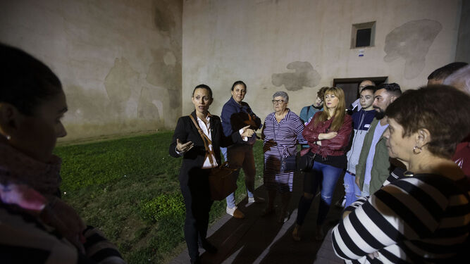 La guía ofrece explicaciones a los participantes de la ruta en los exteriores del Castillo de San Romualdo.