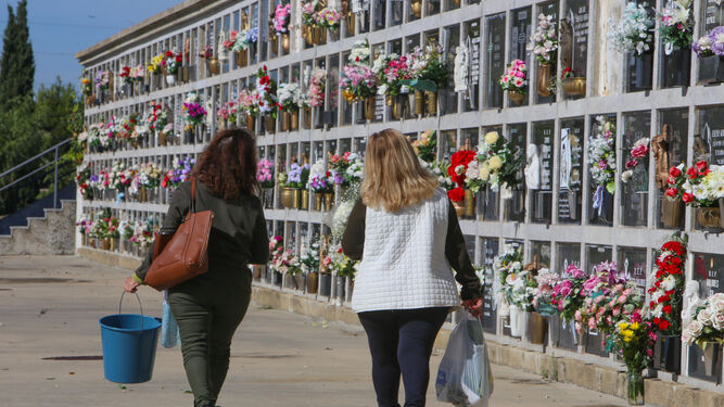 Familiares llevando ayer flores a sus seres queridos en el cementerio de Chiclana