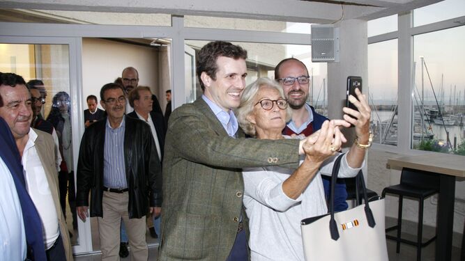 Pablo Casado haciendose un 'selfie' con una de sus simpatizantes a la entrada del salón en la planta alta en la terraza del hotel Puerto Sherry.
