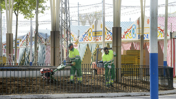 Imagen de dos operarios mientras trabajaban en la preparación del recinto ferial el año pasado.