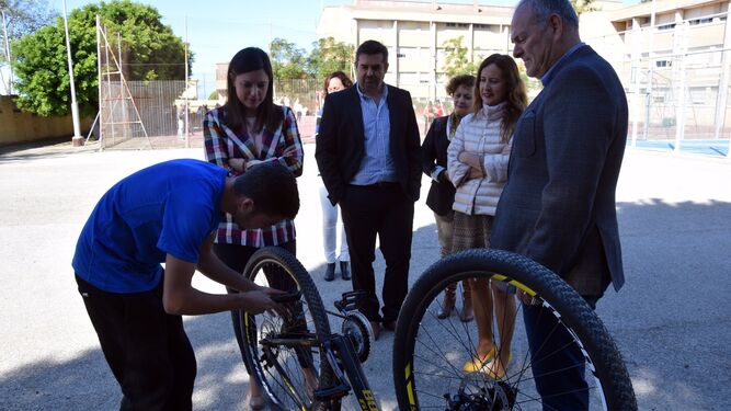 Un alumno del grado medio de Conducción de Actividades Físico-Deportivas, con la bicicleta, junto a la alcaldesa y la delegada territorial de Educación, esta mañana.