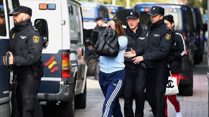 Varios agentes de la Policía Nacional conducen a víctimas de la explotación sexual de mujeres en Madrid.