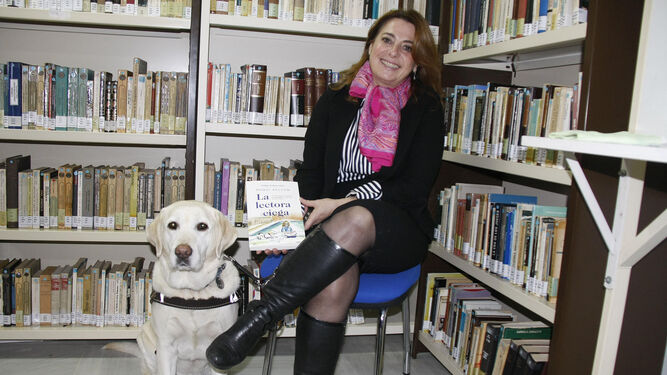 Paqui Ayllón con su perro guía en la biblioteca de El Puerto.
