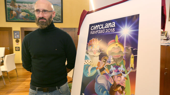 El autor del afiche, Antonio Vela, posa junto a su obra.