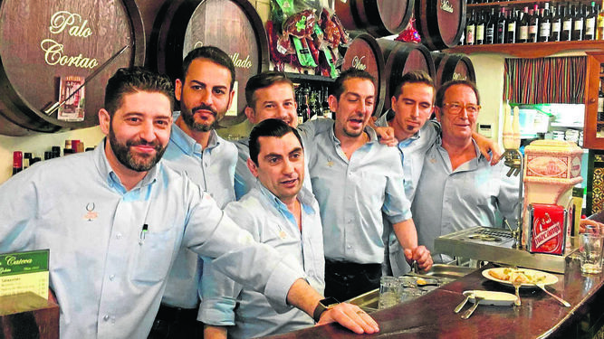 Los empleados de la Taberna Manolo Cateca posan en la barra.