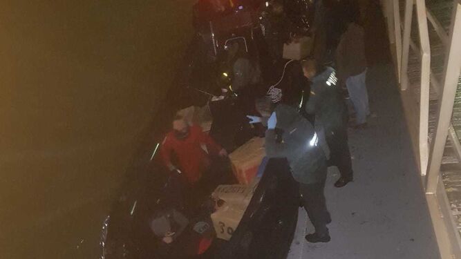 Agentes de la Guardia Civil recuperan los fardos de la embarcación intervenida.