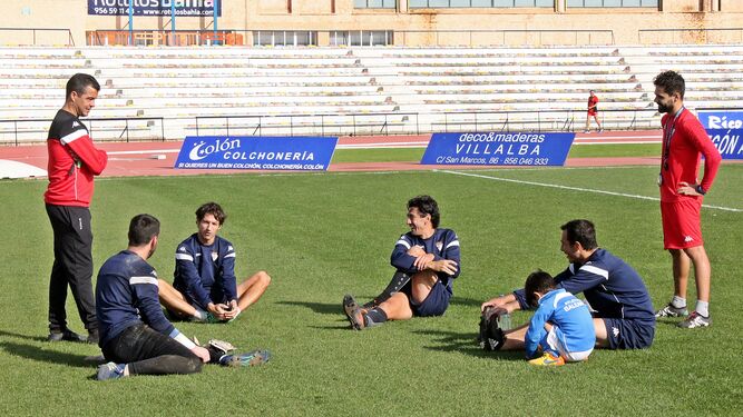Pérez Herrera y Txema, preparador físico, charlan con varios jugadores.