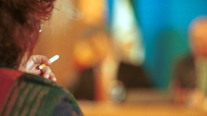 Una mujer fumándose un cigarrillo.