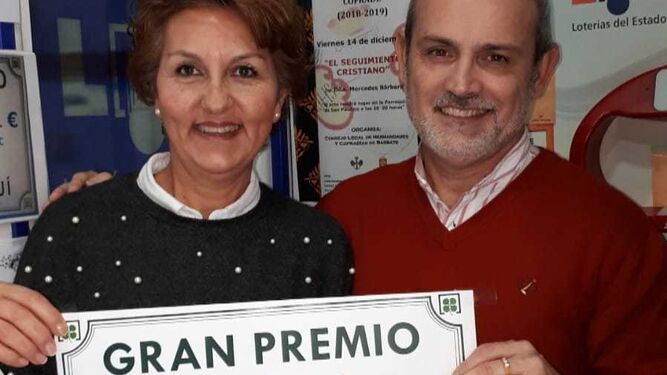 Diego Castillo sostiene junto a su esposa Isabel María Gutiérrez-Rave el cartel del premio de la Bonoloto.