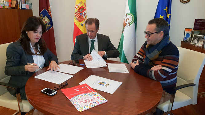 La directora de Cáritas Diocesana de Cádiz en la firma del convenio con el alcalde y el edil de Servicios Sociales.