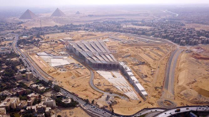 Una vista aérea de las descomunales obras del Gran Museo Egipcio, con las pirámides de Guiza al fondo.