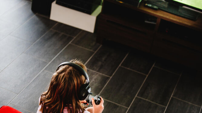 Una niña jugando con una videoconsola.