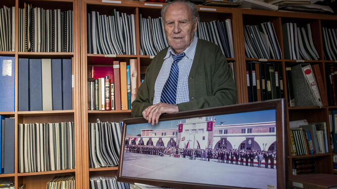 Manuel Parodi, en su estudio, rodeado de recuerdos del Cuartel de Instrucción de Marinería, entre ellos, una fotografía de una jura de bandera.