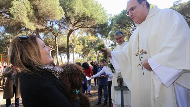 El párroco Antonio Durán, bendiciendo a uno de los perros participantes.