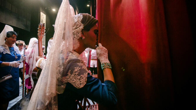 Un corista de mantilla besa las cortinas del escenario del Falla.