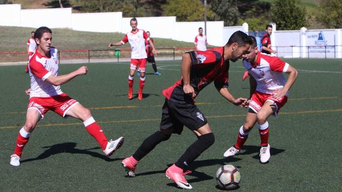 Sergio ‘Piojo’ se lleva el balón ante dos rivales en el partido frente al Ubrique.